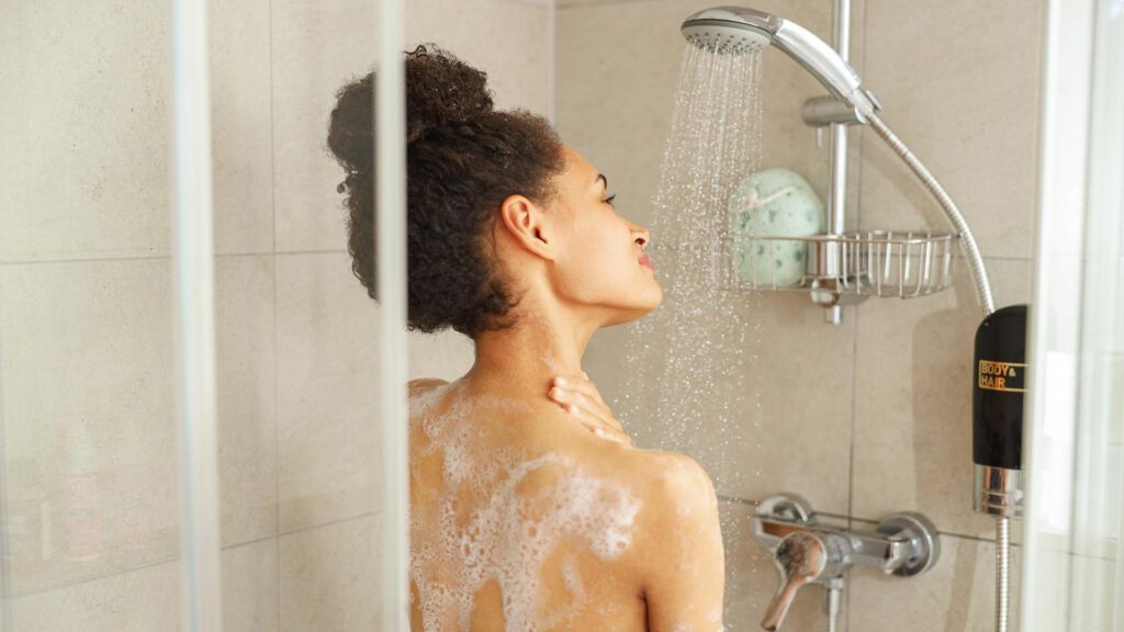 Woman taking shower to get rid of self tanner smell