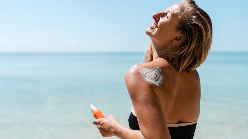 Woman using sunscreen at beach