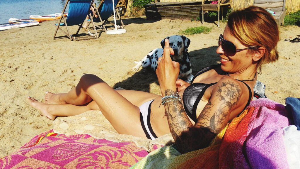 Woman tanning with tattoos tanning at beach