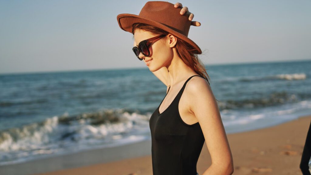 Woman wearing hat and sunglasses to prevent tanning