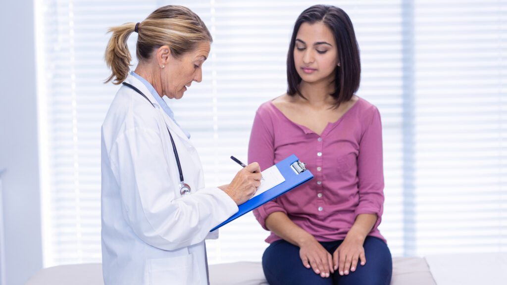 Doctor checking woman for having tan bed rash
