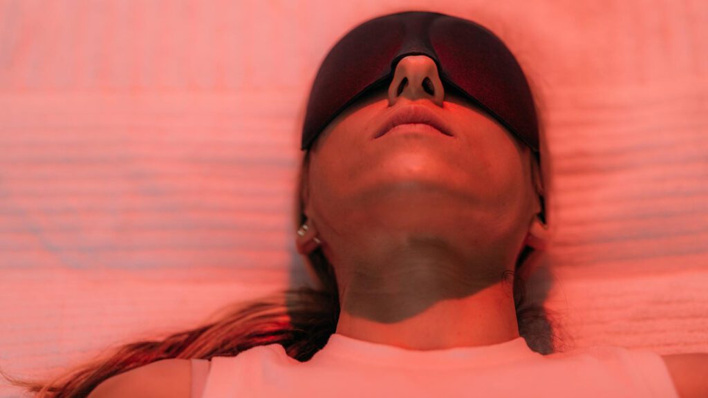 Lady covering her eyes while having red light therapy