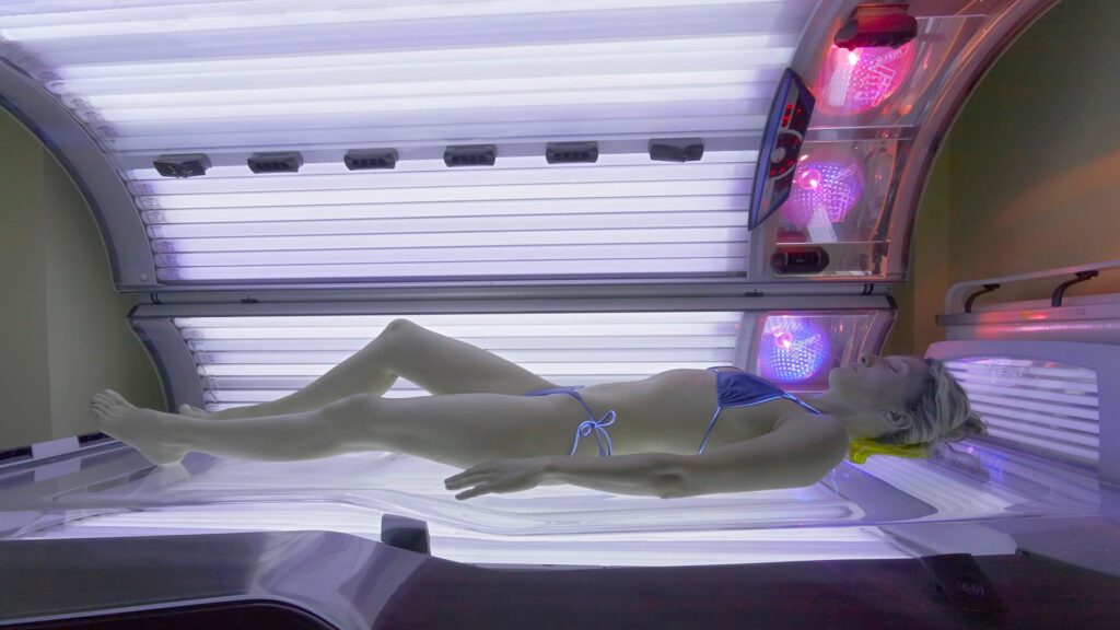woman lying in tanning bed to help acne
